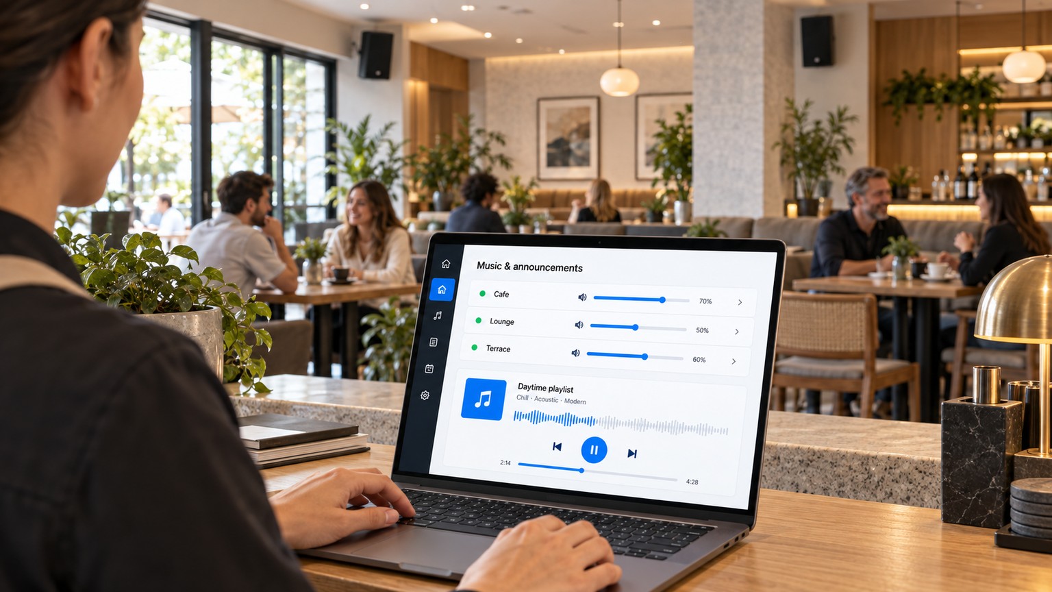 Gestión de música en una cafetería desde un portátil con altavoces de pared conectados